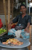 Man from host community selling goods in a Rohingya kitchen market
